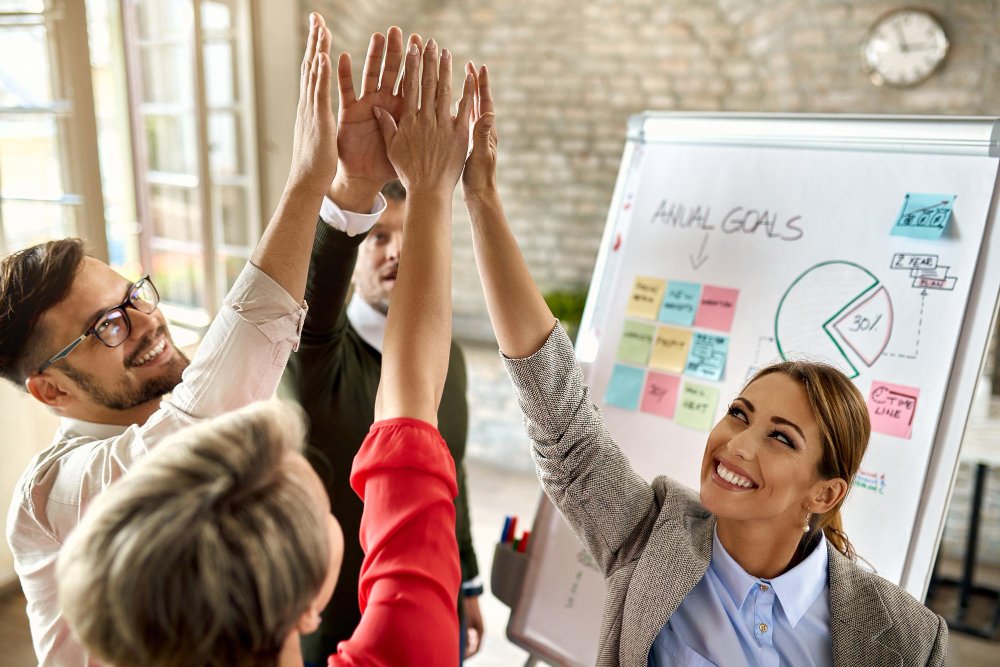 equipo-negocios-feliz-manos-levantadas-celebrando-su-exito-oficina